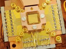 a close up of a copper and gold circuit board with screws and wires