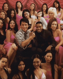a group of women are posing for a picture with a man in a suit