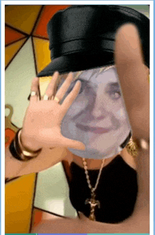 a woman wearing a hat and a necklace has a picture of her face on her face .