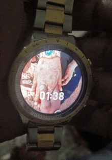 a watch with a picture of a couple holding hands and the time 01:38