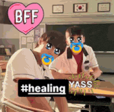 two boys with pacifiers on their faces in a classroom with a pink heart that says bff and #healing yass