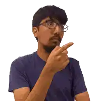 a man wearing glasses and a blue shirt is pointing his finger at something