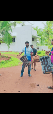 a man playing a drum in front of a building