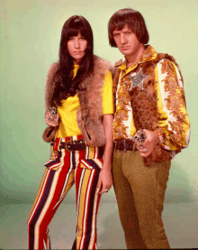 a man and a woman standing next to each other with guns in their hands