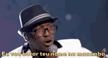 a man singing into a microphone with the words " eu vou botar teu nome na macumba " below him