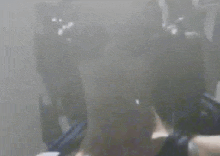 a blurry picture of a person standing in a room with smoke coming out of a window .