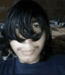 a young man with long black hair and a mustache is taking a selfie with his hair covering his face .