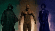 three men are standing next to each other in a dark room . one of the men is naked .