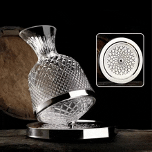 a clear glass vase with a silver rim sits on a table