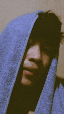 a close up of a person with a blue towel over their head