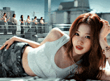 a woman in a white tank top is laying on the floor