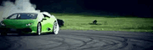 a green lamborghini huracan is drifting on a track .