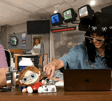 a woman wearing a cowboy hat is sitting at a desk in front of a sign that says a new timeline is coming