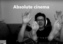 a man sitting on a couch with his feet up and the words " absolute cinema " behind him