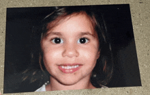 a close up of a little girl 's face with a smile on her face