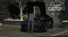 a man works on a car in front of a sign that says auto repair los santos customs