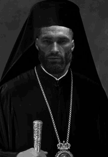 a black and white photo of a priest holding a crown