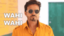 a man wearing sunglasses and a yellow shirt with the words wahi wahi above him