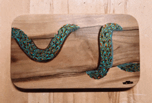 a painting of a snake on a wooden surface