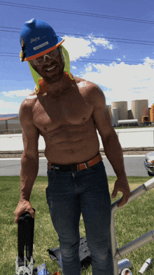 a shirtless man wearing a skyline hard hat and glasses