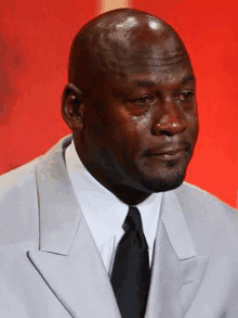 a close up of a man in a suit and tie crying .