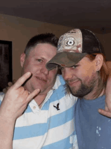 two men posing for a picture one wearing a hat that says ' texas ' on it