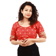 a woman is wearing a red blouse with gold embroidery