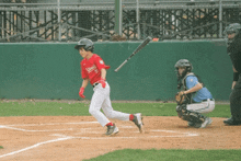 a baseball player wearing a red jersey that says louisville on it