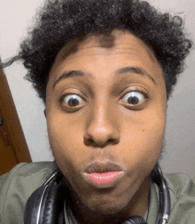 a young man wearing headphones makes a funny face