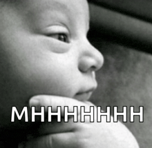a black and white photo of a baby with a caption that says mhhhhh