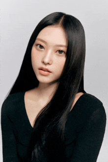 a woman with long black hair wearing a black top