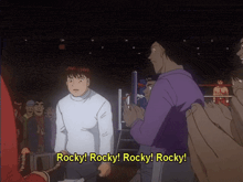 a man in a white shirt stands in front of a crowd and says rocky