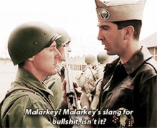 a man in a military uniform talks to another man in a military uniform