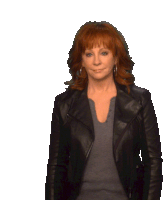 a woman with red hair is wearing a black jacket