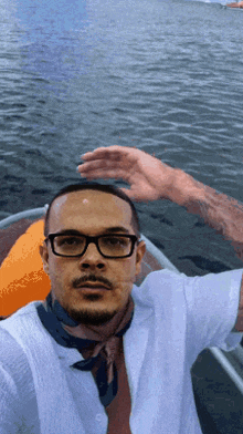 a man wearing glasses and a scarf is sitting in a boat