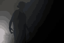 a silhouette of a person holding a sword in the dark