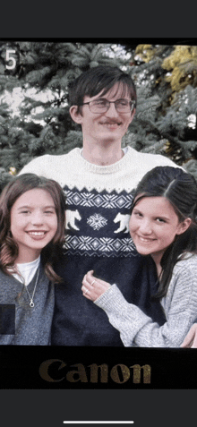 a man with glasses and a mustache is posing for a photo with two girls