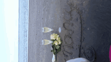 two glasses of champagne and a bouquet of flowers on the beach