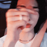 a close up of a woman covering her face with her hand