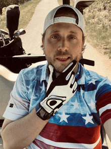 a man wearing an american flag shirt and a glove with the letter a on it