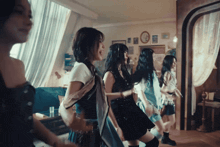 a group of women are dancing in a living room