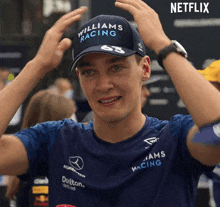 a man wearing a hat that says williams racing