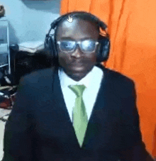 a man wearing a suit and tie is wearing headphones and glasses .