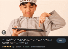 a boy is holding a tablet and pointing at it with a visit button below him