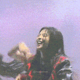 a woman in a red and black plaid shirt is laughing
