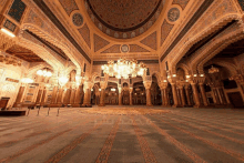 the inside of a mosque with arabic writing on the walls and ceiling