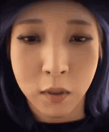 a close up of a woman 's face with a blue hood .