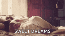 a man and woman are laying in bed with the words `` sweet dreams '' written on the bottom .