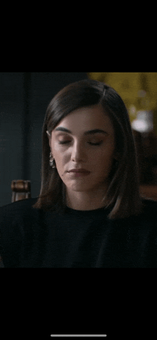 a close up of a woman 's face with her eyes closed in a dark room