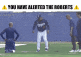 a dodgers baseball player is kneeling on the field with a warning sign above him that says you have alerted the roberts